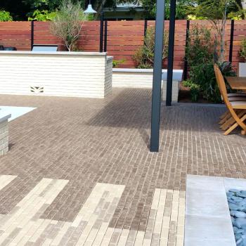 A residential outdoor patio featuring brick pavers