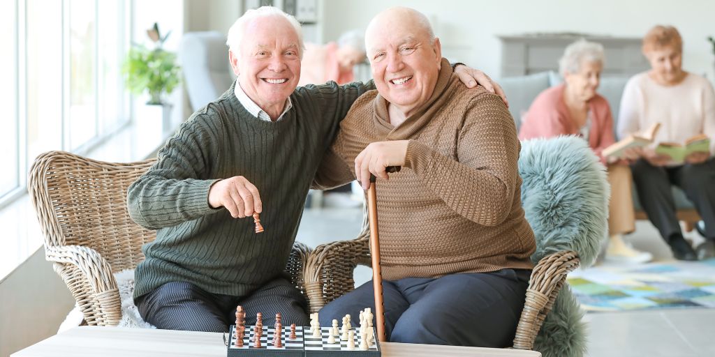 2 elderly men with a chess game on a coffee table