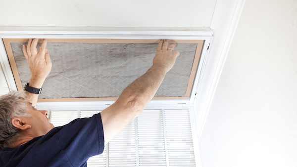 Stock photo of someone replacing ac filter or some indoor maintenance