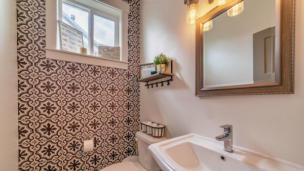 Bathroom with a busy black and white wallpaper accent wall