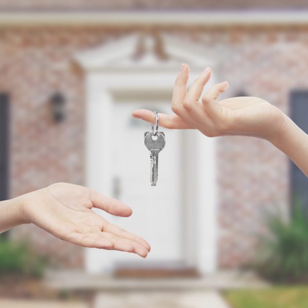 Mani con chiavi sfondo casa entrata