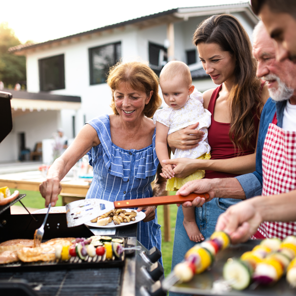 Family gathers around the outdoor grill